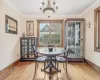 Dining area with hardwood / wood-style floors, an inviting chandelier, and crown molding