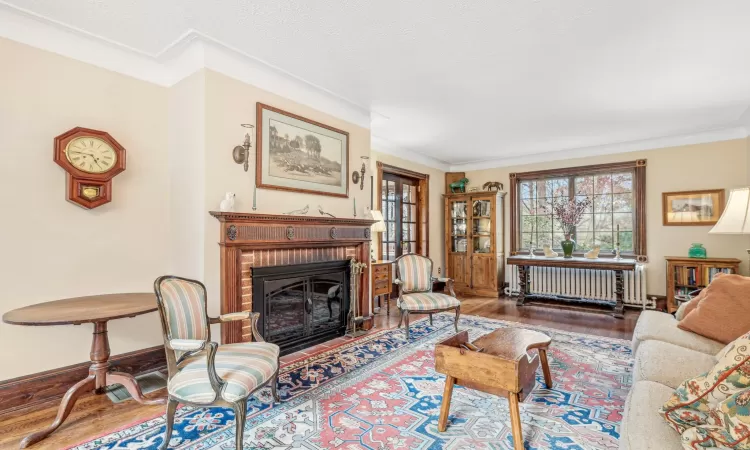 Living room featuring radiator, hardwood / wood-style floors, and ornamental molding