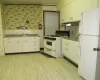 Kitchen featuring white cabinets, light wood-type flooring, white appliances, and sink