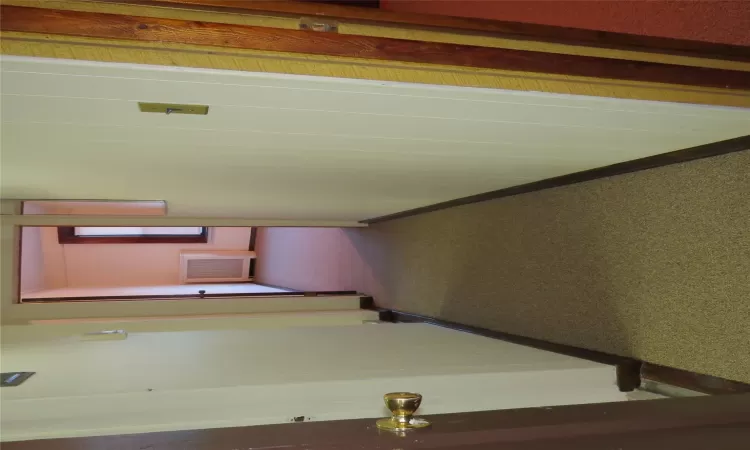 Corridor featuring radiator heating unit and dark colored carpet