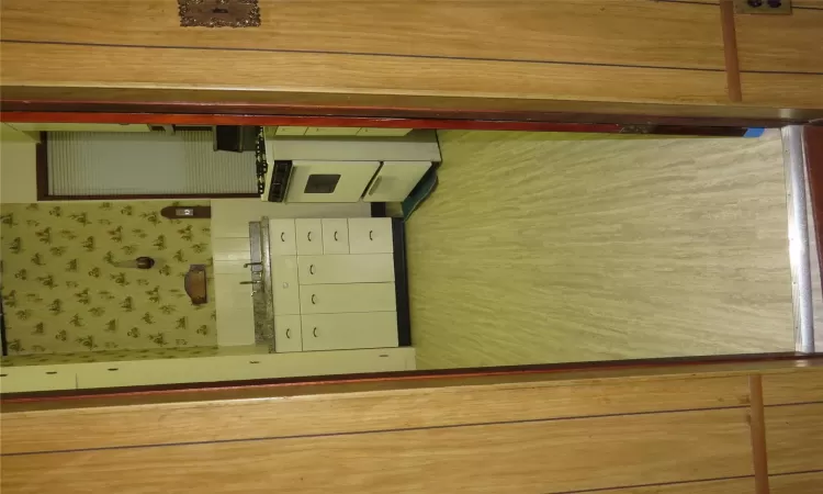 Kitchen with stove, white cabinets, light wood-type flooring, and sink