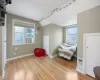 Sitting room featuring cooling unit, lofted ceiling, and light wood-type flooring