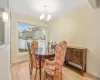 Dining room with light wood-type flooring, plenty of natural light, and a notable chandelier