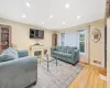 Living room with crown molding and light hardwood / wood-style floors