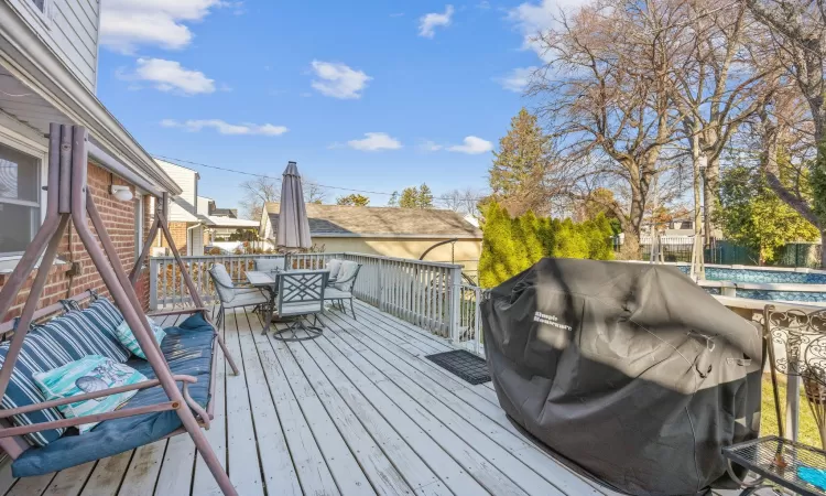 Wooden terrace featuring a grill