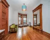 Unfurnished room featuring radiator, wood-type flooring, a wealth of natural light, and an inviting chandelier