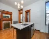 Kitchen featuring a kitchen island with sink, sink, hanging light fixtures, stainless steel dishwasher, and a healthy amount of sunlight