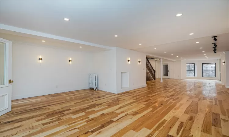 Unfurnished living room featuring light hardwood / wood-style flooring and radiator