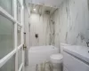 Full bathroom featuring vanity, bathtub / shower combination, tile walls, and toilet