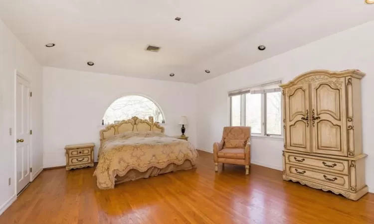 Bedroom with light wood-type flooring and connected bathroom