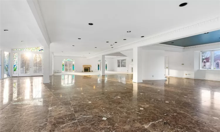 Unfurnished living room with crown molding and french doors