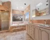 Bathroom featuring shower with separate bathtub, a skylight, and tile walls