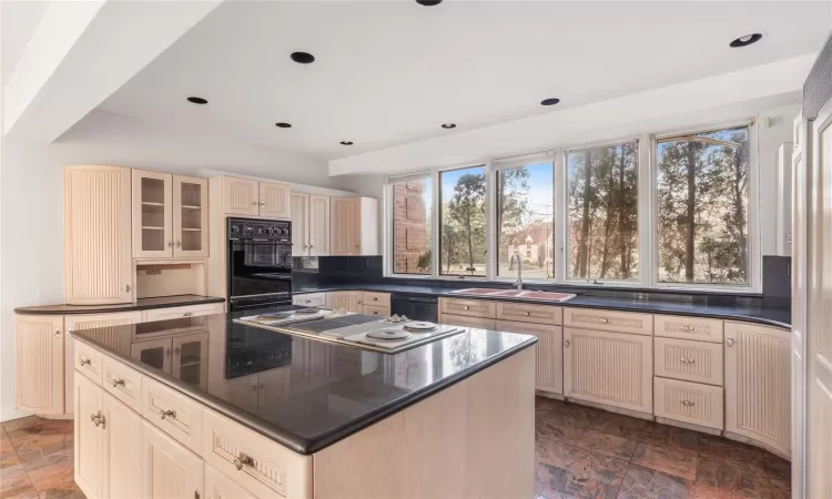 Kitchen with backsplash, sink, a kitchen island, and plenty of natural light