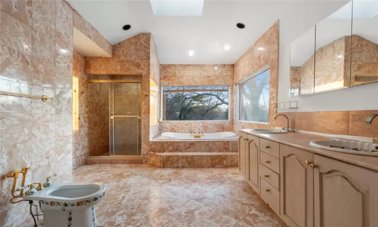 Bathroom featuring sink, a bidet, and tile walls