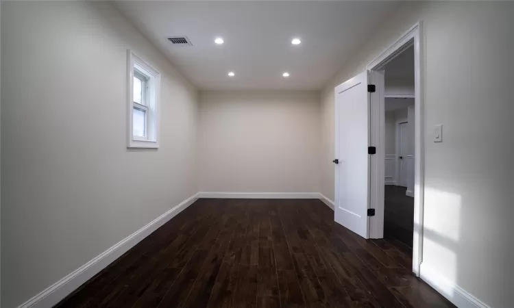 Empty room with dark hardwood / wood-style flooring