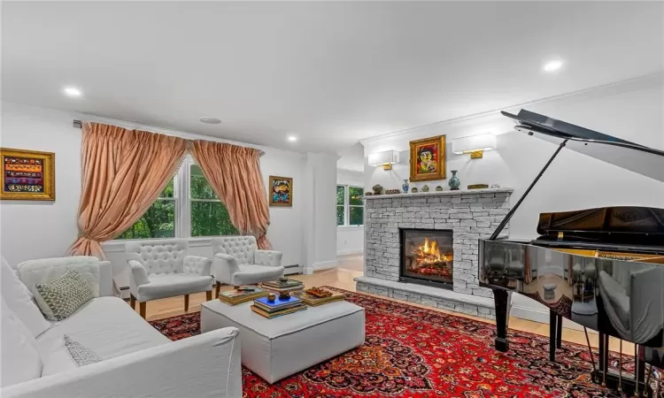 Living room with light hardwood / wood-style floors, built in features, and crown molding