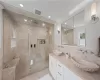 Bathroom featuring double vanity, tile walls, tile floors, crown molding, and an enclosed shower