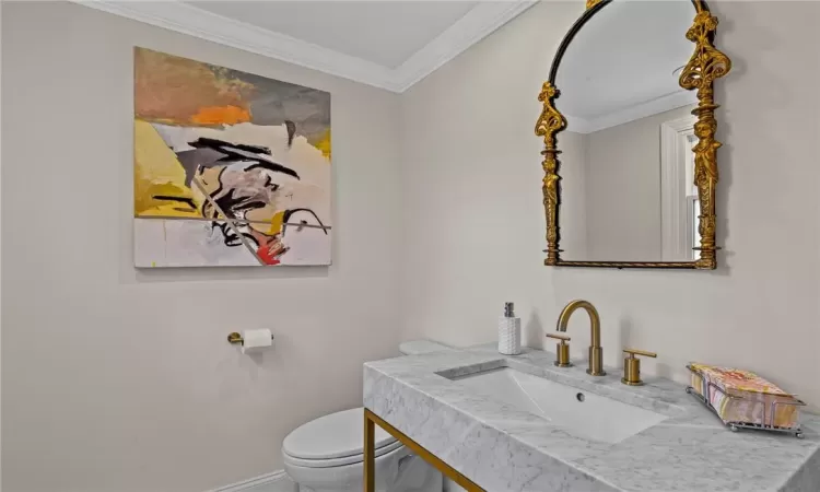 Bathroom featuring ornamental molding, toilet, and vanity