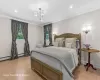 Bedroom with light hardwood / wood-style floors, a notable chandelier, and ornamental molding