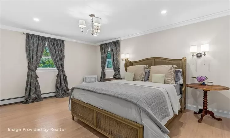 Bedroom with light hardwood / wood-style floors, a notable chandelier, and ornamental molding