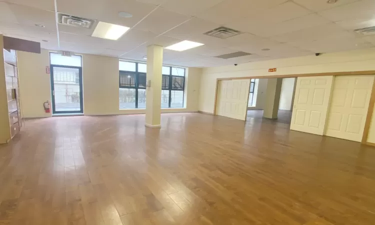 Empty room featuring a drop ceiling and hardwood / wood-style floors