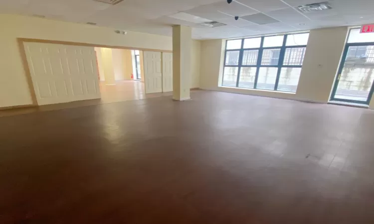 Empty room with a paneled ceiling and a wealth of natural light