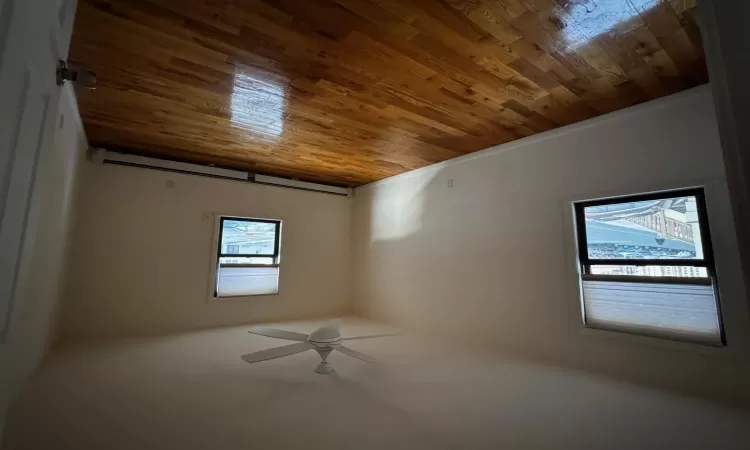 Spare room featuring ceiling fan, hardwood / wood-style floors, and a baseboard heating unit