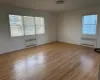 Empty room with radiator heating unit and light hardwood / wood-style floors