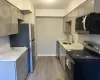 Kitchen featuring light wood-type flooring, stainless steel appliances, gray cabinets, and sink