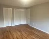 Unfurnished bedroom with two closets and hardwood / wood-style flooring