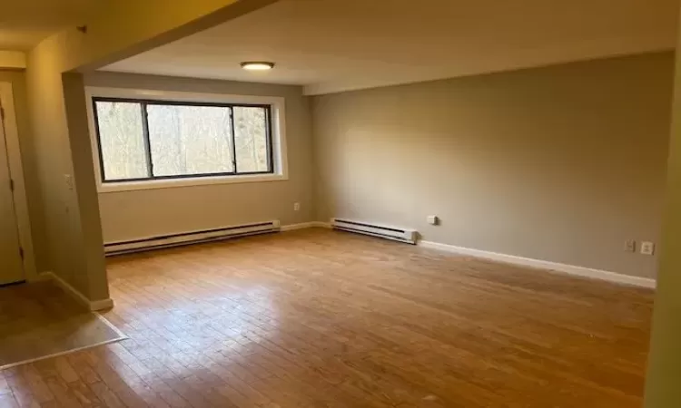 Spare room with light hardwood / wood-style floors and a baseboard heating unit