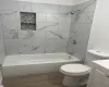 Full bathroom featuring toilet, vanity, wood-type flooring, and tiled shower / bath