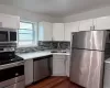 Kitchen featuring sink, white cabinets, and appliances with stainless steel finishes