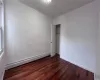 Unfurnished bedroom with dark hardwood / wood-style floors, a closet, and a baseboard heating unit