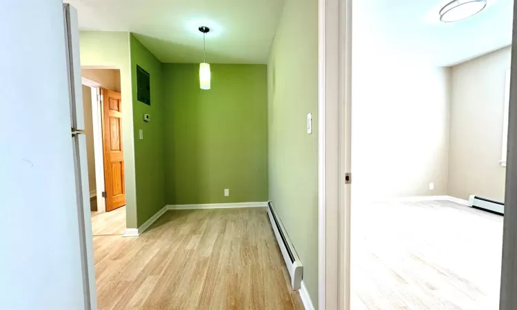 Corridor featuring light hardwood / wood-style flooring and a baseboard radiator