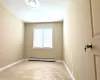 Unfurnished room featuring light hardwood / wood-style flooring and baseboard heating