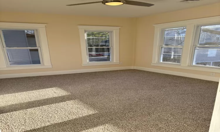 Carpeted spare room featuring ceiling fan