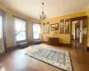 Living area featuring hardwood / wood-style flooring, crown molding, radiator, and a chandelier