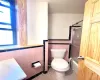 Bathroom with shower / bath combination with glass door, tile patterned flooring, tile walls, and toilet