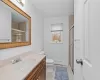 Bathroom with baseboard heating, tile patterned flooring, toilet, a shower with door, and vanity