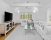 Living room with baseboard heating, ceiling fan, hardwood / wood-style floors, and lofted ceiling with beams