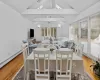 Dining space with baseboard heating, ceiling fan, light hardwood / wood-style flooring, and beamed ceiling