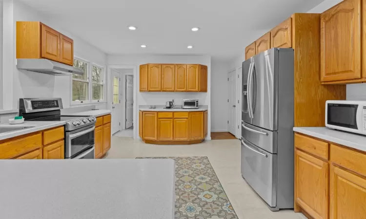 Kitchen featuring light tile patterned floors and appliances with stainless steel finishes