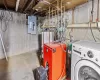 Laundry area with gas water heater, electric panel, and washer / clothes dryer