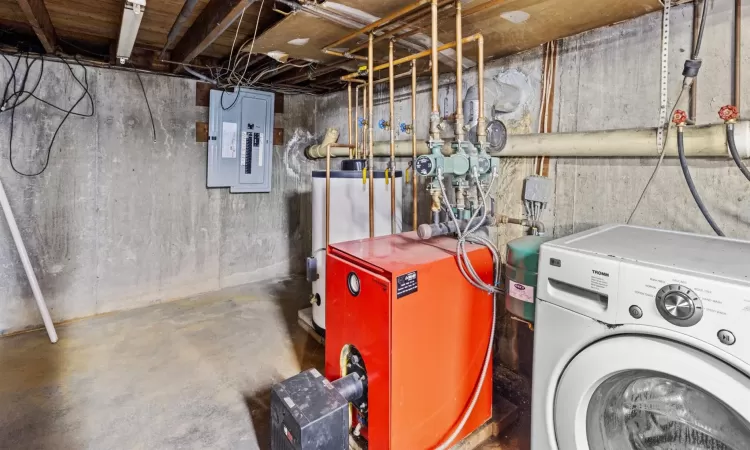 Laundry area with gas water heater, electric panel, and washer / clothes dryer