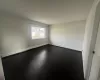 Spare room with baseboard heating and dark hardwood / wood-style floors