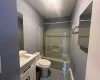 Full bathroom with vanity, toilet, shower / washtub combination, and a baseboard radiator