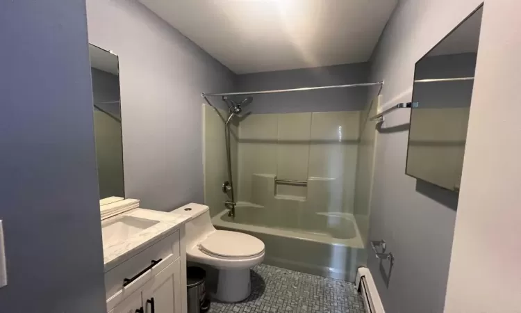 Full bathroom with vanity, toilet, shower / washtub combination, and a baseboard radiator