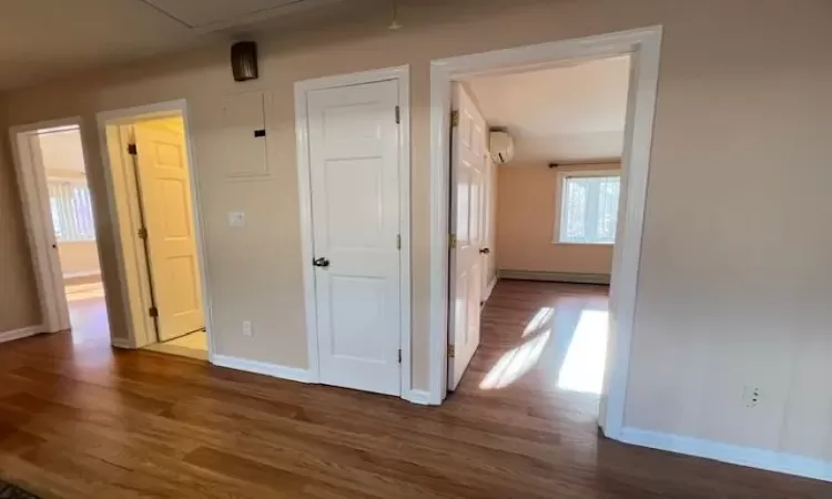 Hall featuring an AC wall unit and dark hardwood / wood-style floors