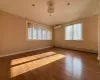 Spare room with a wall mounted air conditioner, wood-type flooring, and baseboard heating